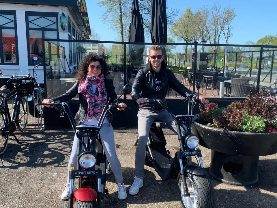 Stel op twee e-choppers bij het terras van Hollands Venetië in Giethoorn