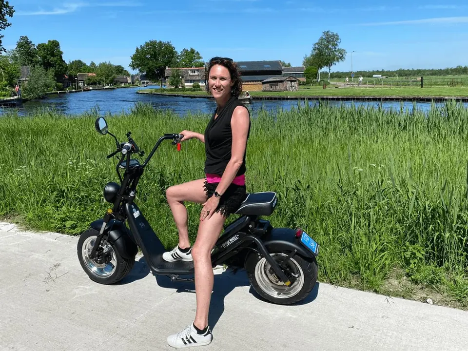 Vrouw op een zwarte e-chopper langs het water in de Weerribben-Wieden
